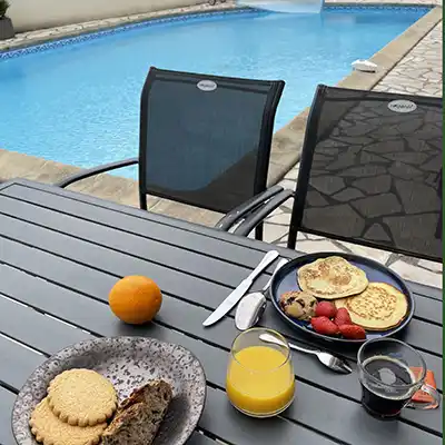 Table petit déjeuner extérieure devant la piscine