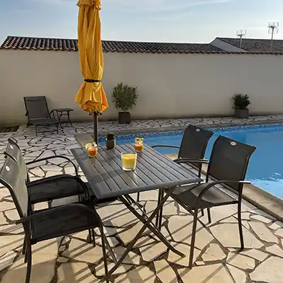 Une table proche de la piscine où vous pourrez jouer à l'ombre du parasol ou prendre votre petit déjeuner le matin